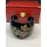 A HEAVY BLACK BANGLE WITH A GOLD AND DIAMOND DECORATION IN THE FORM OF SAGITTARIUS WITH A