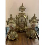 A DECORATIVE MANTLE CLOCK WITH A COURTING COUPLE DESIGN, GARNITURES AND KEY