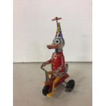 A TIN PLATE DUCK ON A BIKE TOY