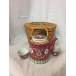 AN ORIENTAL STYLE TEAPOT AND TEA BOWLS COMPLETE WITH A CARRYING BASKET