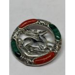 A MARKED SILVER BROOCH WITH RED AND GREEN STONES SURROUNDING A CENTRAL STAG DESIGN