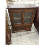 A GLAZED AND LEADED BOOKCASE BY STANLEY WOOD OF OLNEY, 30" WIDE