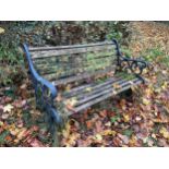 A WOODEN SLATTED GARDEN BENCH WITH CAST BENCH ENDS (L:129CM)