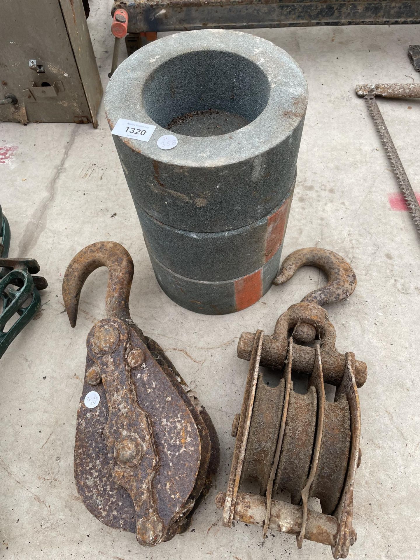 TWO LARGE PULLEY HOOKS AND A SET OF THREE GRIND STONES