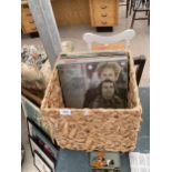 A WICKER BASKET WITH AN ASSORTMENT OF LP RECORDS