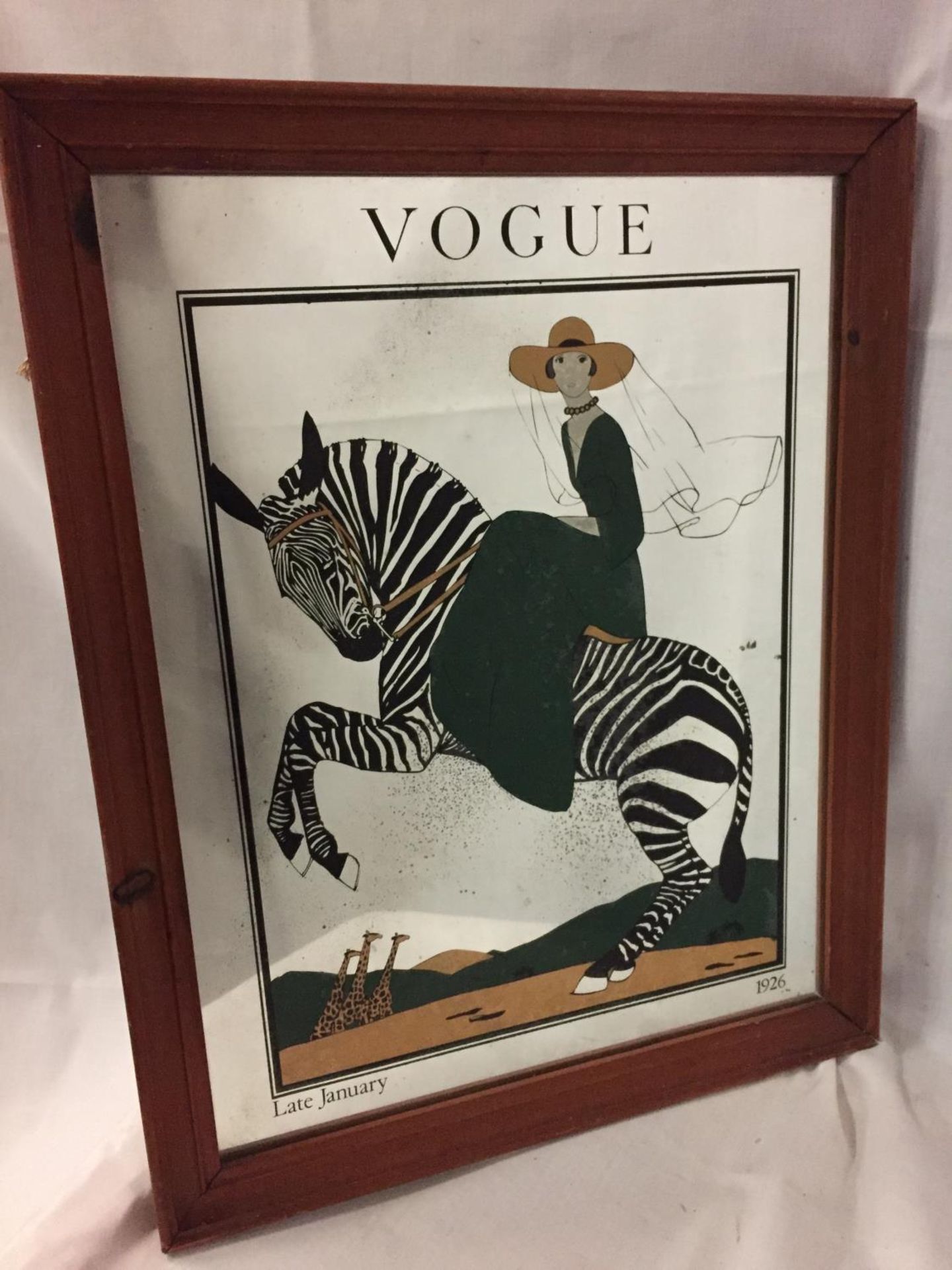 A MIRROR WITH A PICTURE OF A LADY ON A ZEBRA ADVERTISING VOGUE