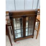 AN EARLY 20TH CENTURY GLAZED AND LEADED TWO DOOR BOOKCASE, 27" WIDE