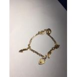 A TESTED TO 14 CARAT GOLD CHARM BRACELET WITH THREE CHARMS AND A HEART PADLOCK ALL MARKED 18 CARAT