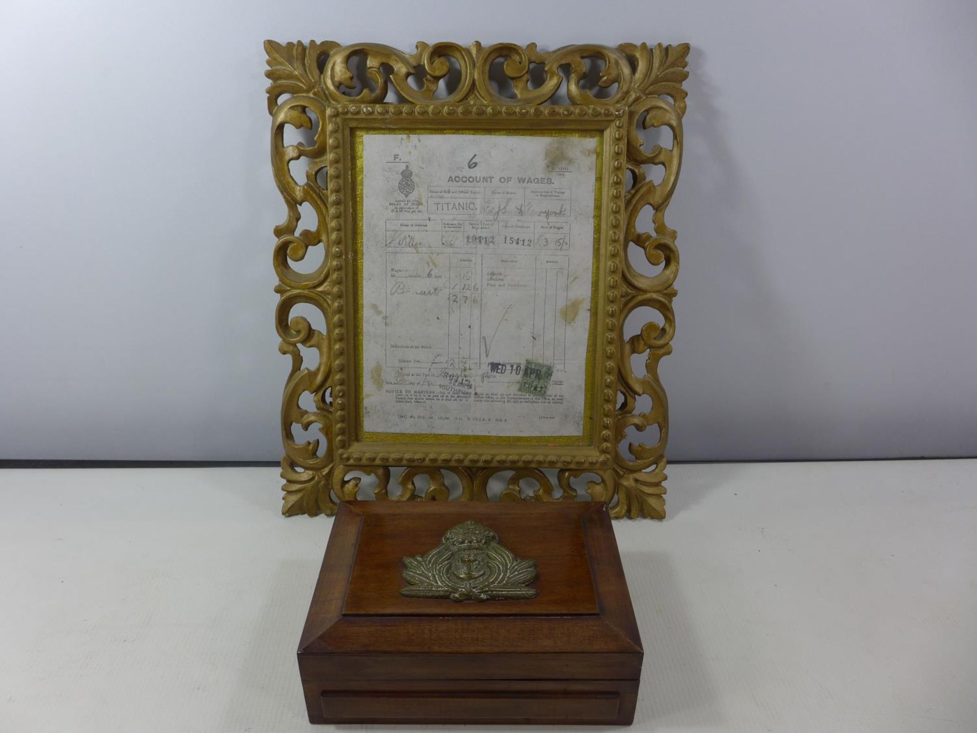A MAHOGANY BOX WITH BRASS NAVAL BADGE AND A FRAMED ACCOUNT OF WAGES MARKED TITANIC, DATED 1912, 22 X