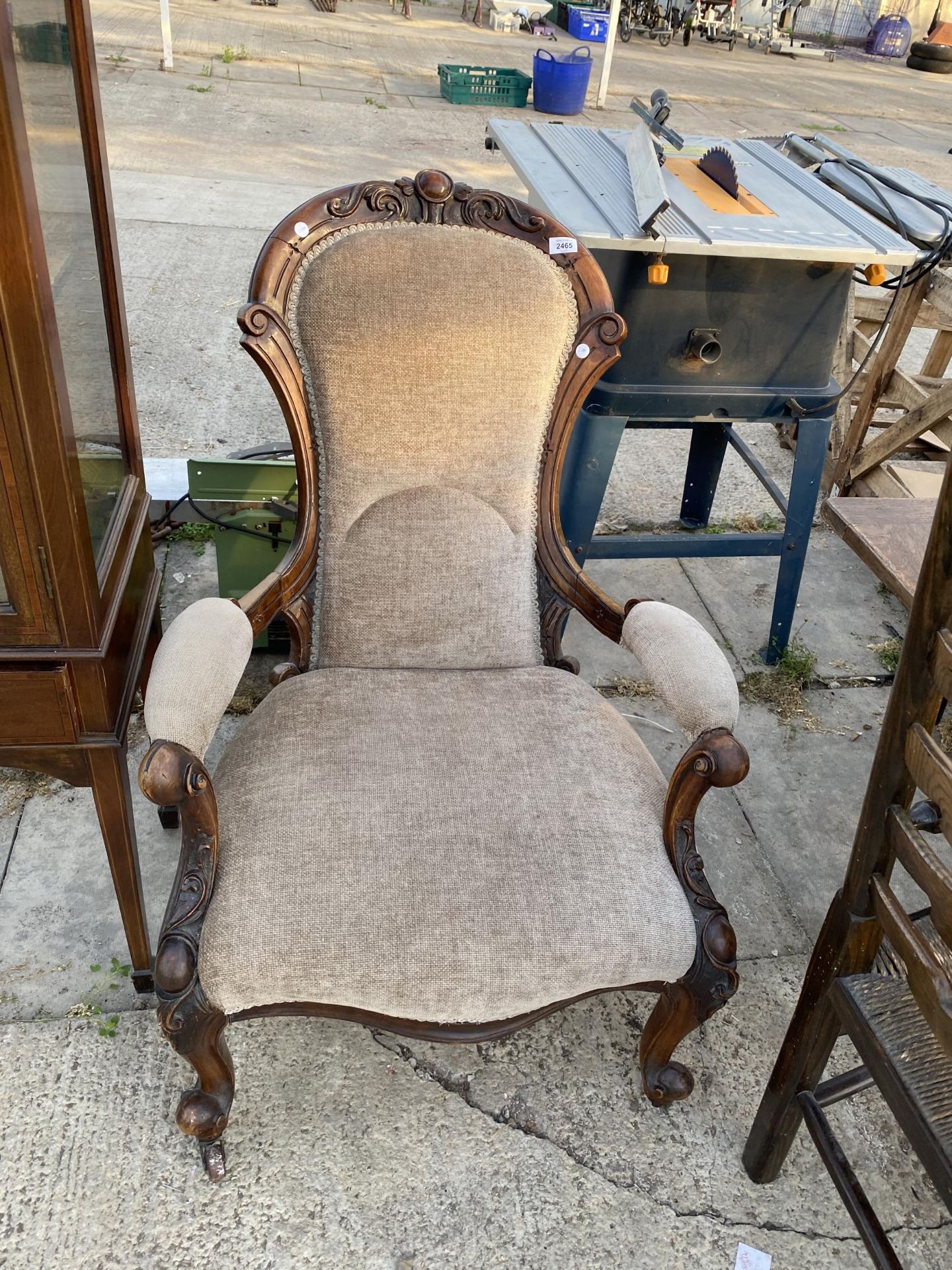 A VICTORIAN WALNUT FIRESIDE CHAIR WITH OPEN ARMS, ON CABRIOLE LEGS