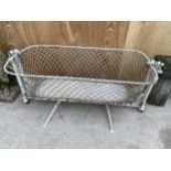 A VINTAGE METAL SWINGING CHILDS CRIB WITH ROPE SIDES