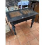 A VICTORIAN EBONISED GAMES TABLE WITH CHESS BOARD TOP AND TWO DRAWERS ON CARVED SUPPORTS 100CM X