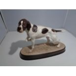 A BESWICK POINTER ON A CERAMIC PLINTH