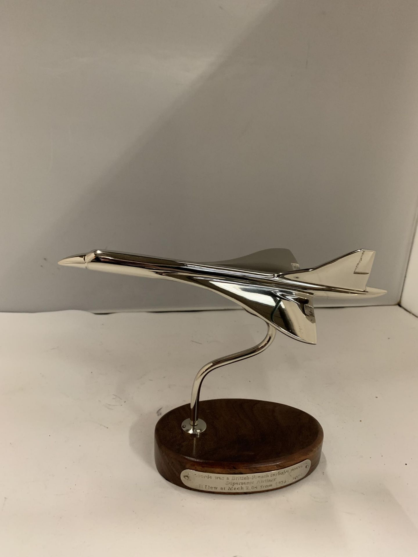 A CHROME MODEL OF CONCORDE ON A WOODEN PLINTH HEIGHT 17CM