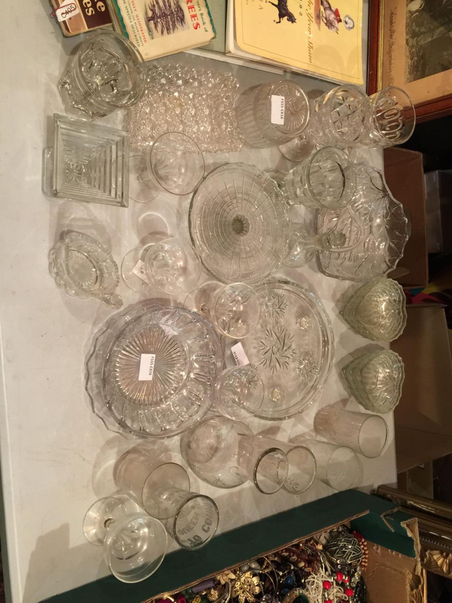 A LARGE AMOUNT OF CLEAR GLASSWARE TO INCLUDE HEART SHAPED DISHES, COMMEMORATIVE TUMBLERS, CAKE