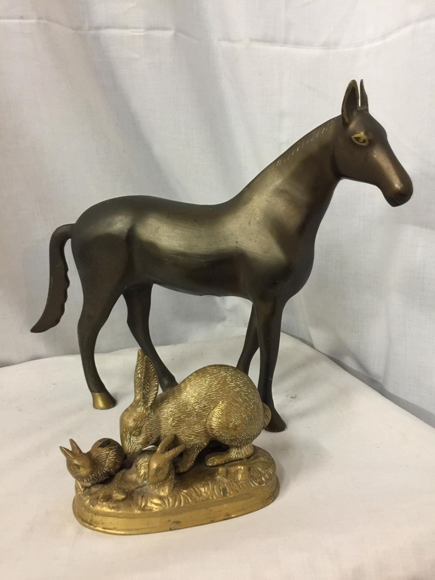 A HEAVY BRONZE EFFECT METAL HORSE FIGURINE, HEIGHT 30CM, WIDTH APPROX 41CM, TOGETHER WITH A BRASS