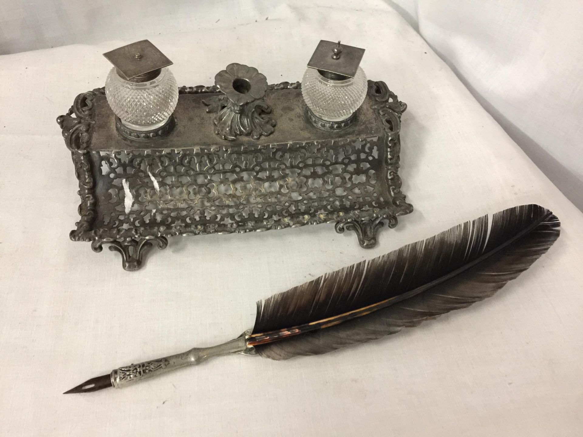 AN ORNATE FILIGREE STYLE SILVER PLATE DESK SET COMPRISING TWO GLASS INK WELLS WITH SILVER PLATE LIDS