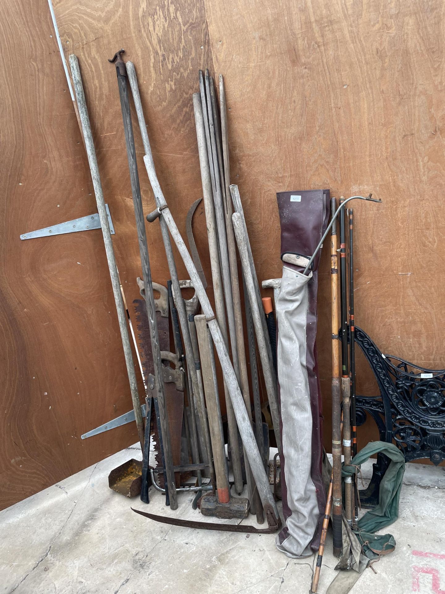 A LARGE ASSORTMENT OF VINTAGE GARDEN TOOLS TO INCLUDE A SLEDGE HAMMER, SPADES AND LARGE SAWS ETC