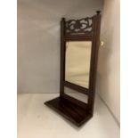 A WOODEN WALL MIRROR WITH A DECORATIVE TOP AND A SHELF
