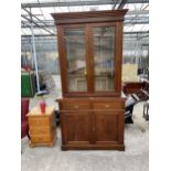 A LATE VICTORIAN TWO DOOR GLAZED BOOKCASE ON BASE WITH CARVED DODORS, 42" WIDE