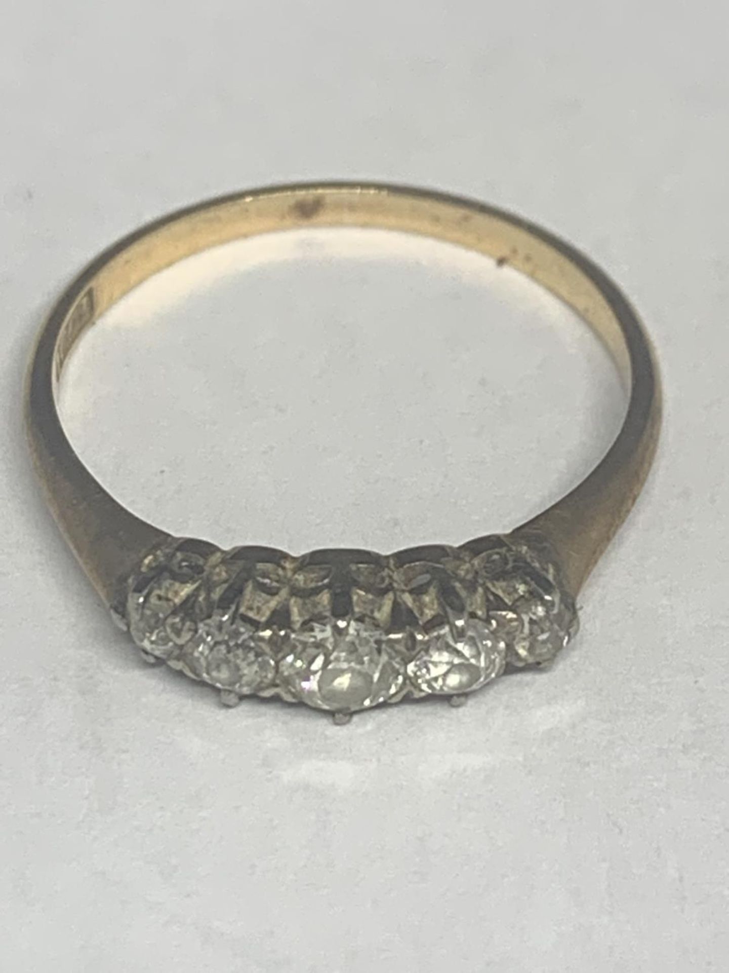 A MARKED 18 CT GOLD RING WITH FIVE GRADUATED IN LINE DIAMONDS SIZE P/Q GROSS WEIGHT 1.9 GRAMS