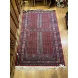 A CAUCASIAN PRAYER RUG ON A BURGUNDY GROUND WITH GEOMETRIC DECORATION 160CM X 95CM