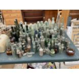 A LARGE QUANTITY OF GREEN, BLUE, BROWN AND CLEAR VINTAGE GLASS BOTTLES