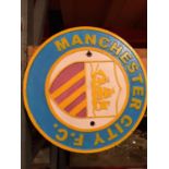 A ROUND CAST MANCHESTER CITY SIGN