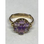 A 9 CARAT GOLD RING MARKED 9CT WITH A PURPLE STONE POSSIBLY AMETHYST FLOWER DESIGN SIZE L WITH