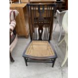 A LOW BEECH HIGH-BACK NURSING CHAIR WITH CANE SEAT