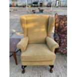 A PARKER KNOLL WINGED FIRESIDE CHAIR ON CABRIOLE LEGS