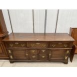 A GEORGE III OAK DRESSER BASE WITH FOUR SHORT, THREE LONG DRAWERS AND TWO CUPBOARDS, ON BRACKET