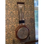 A WALL MOUNTED ANEROID BAROMETER