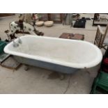 A LARGE HEAVY CAST IRON BATH WITH TWO TAPS