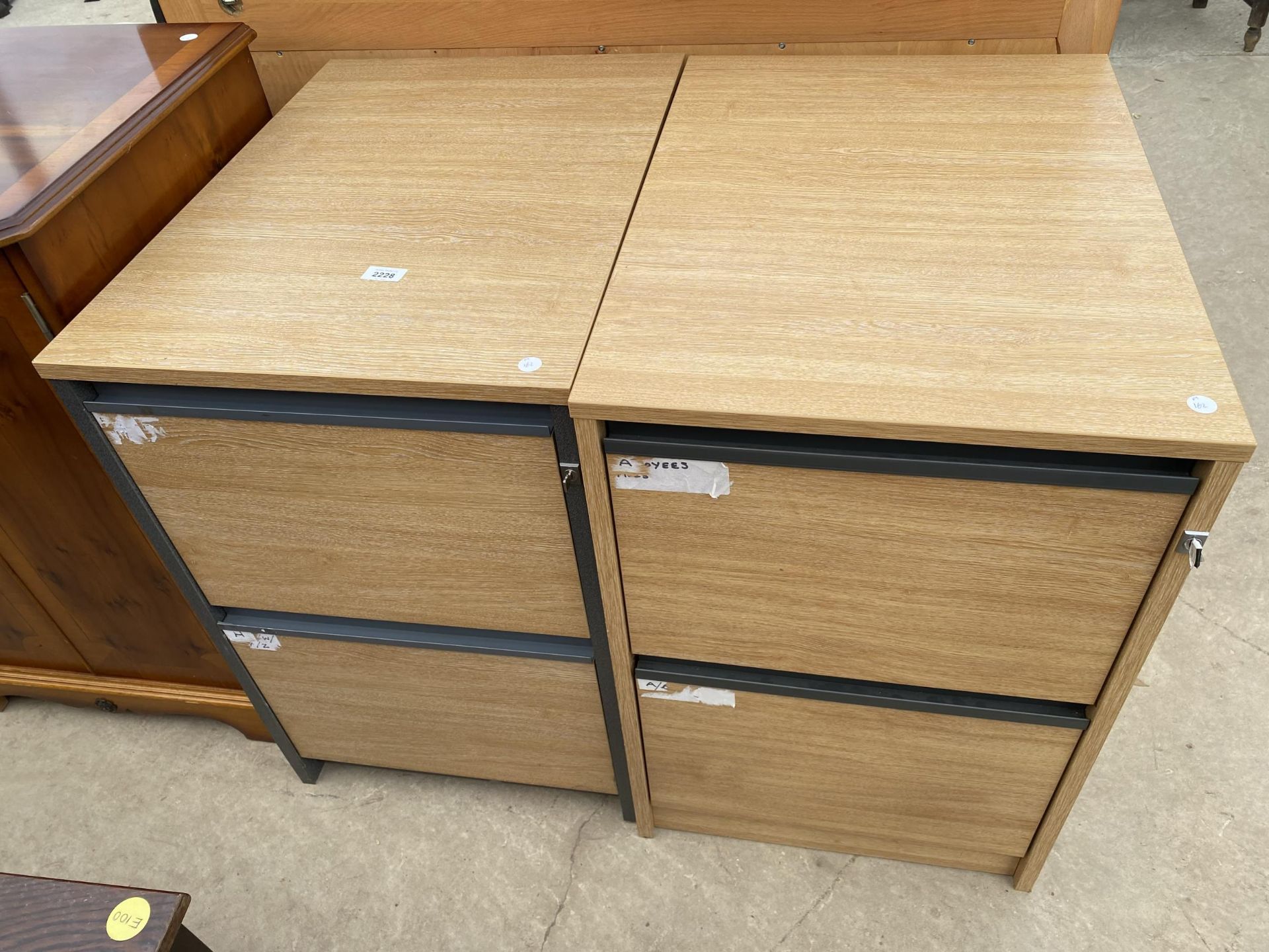 A PAIR OF LIMED OAK EFFECT TWO DRAWER FILING CABINETS COMPLETE WITH TWO KEYS