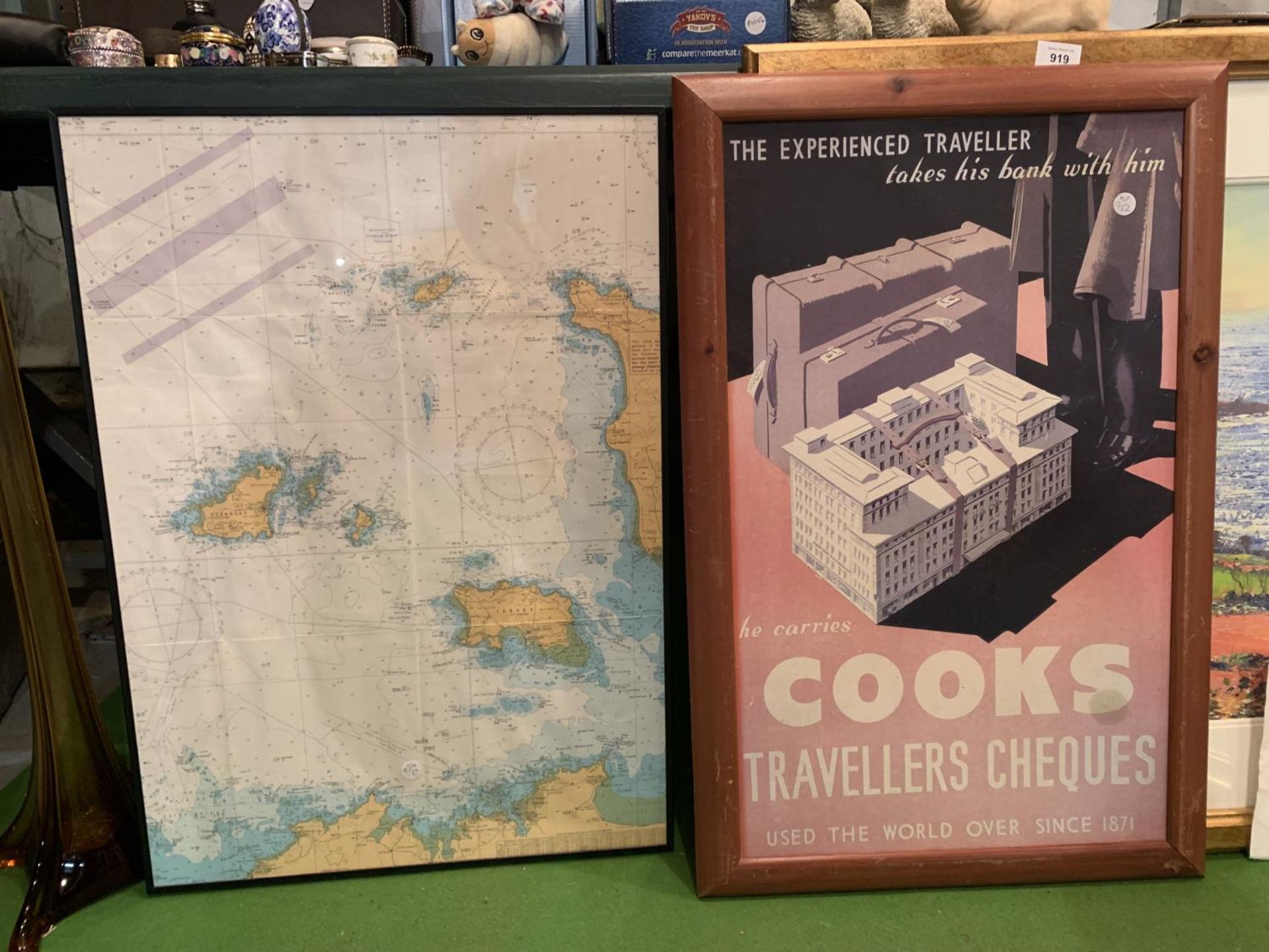 A FRAMED MAP OF THE CHANNEL ISLANDS AND A FRAMED ADVERTISING POSTER FOR TRAVELLERS CHEQUES