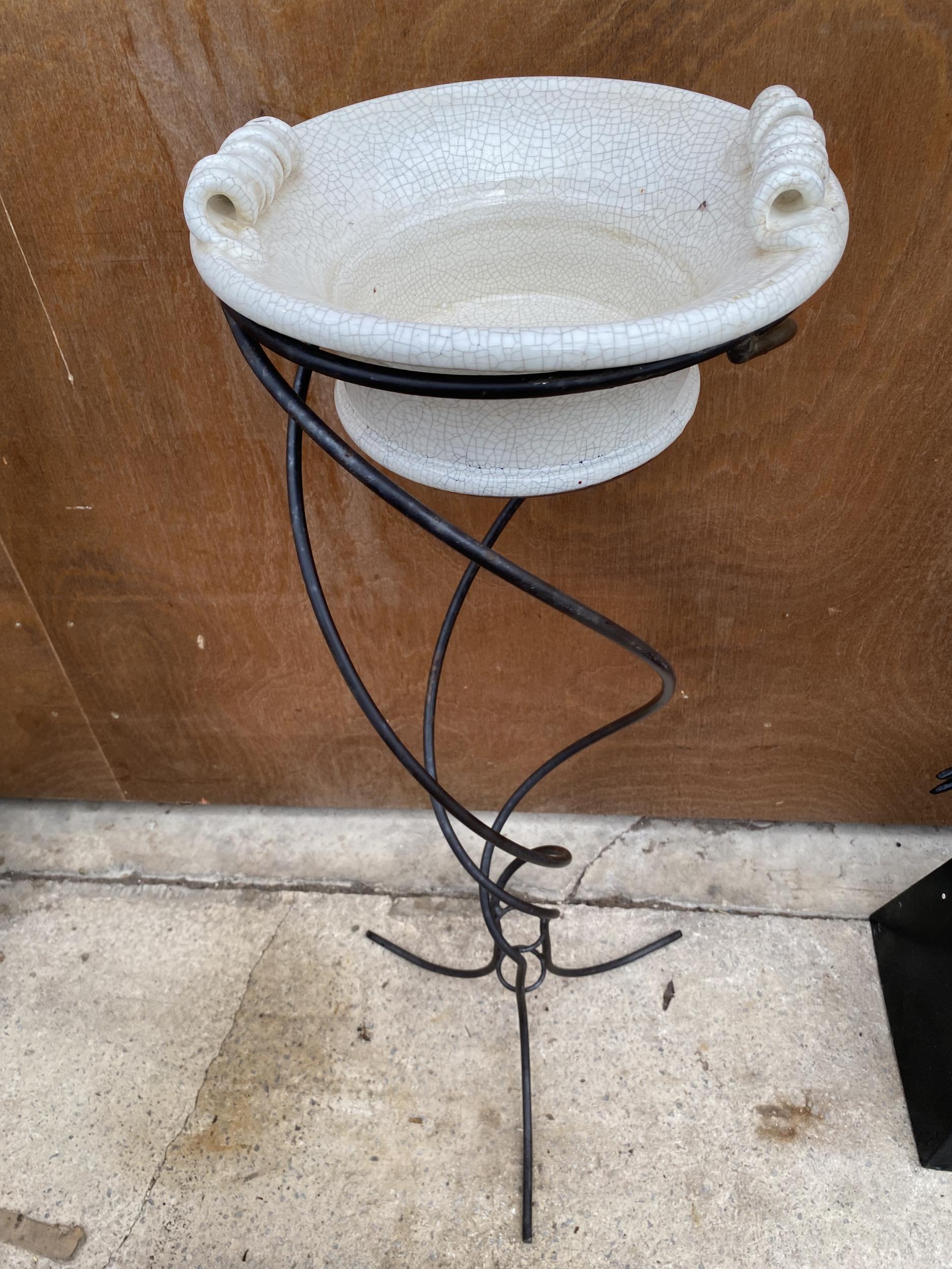 A VINTAGE CERAMIC WASH BOWL ON A DECORATIVE TURNED WROUGHT IRON STAND