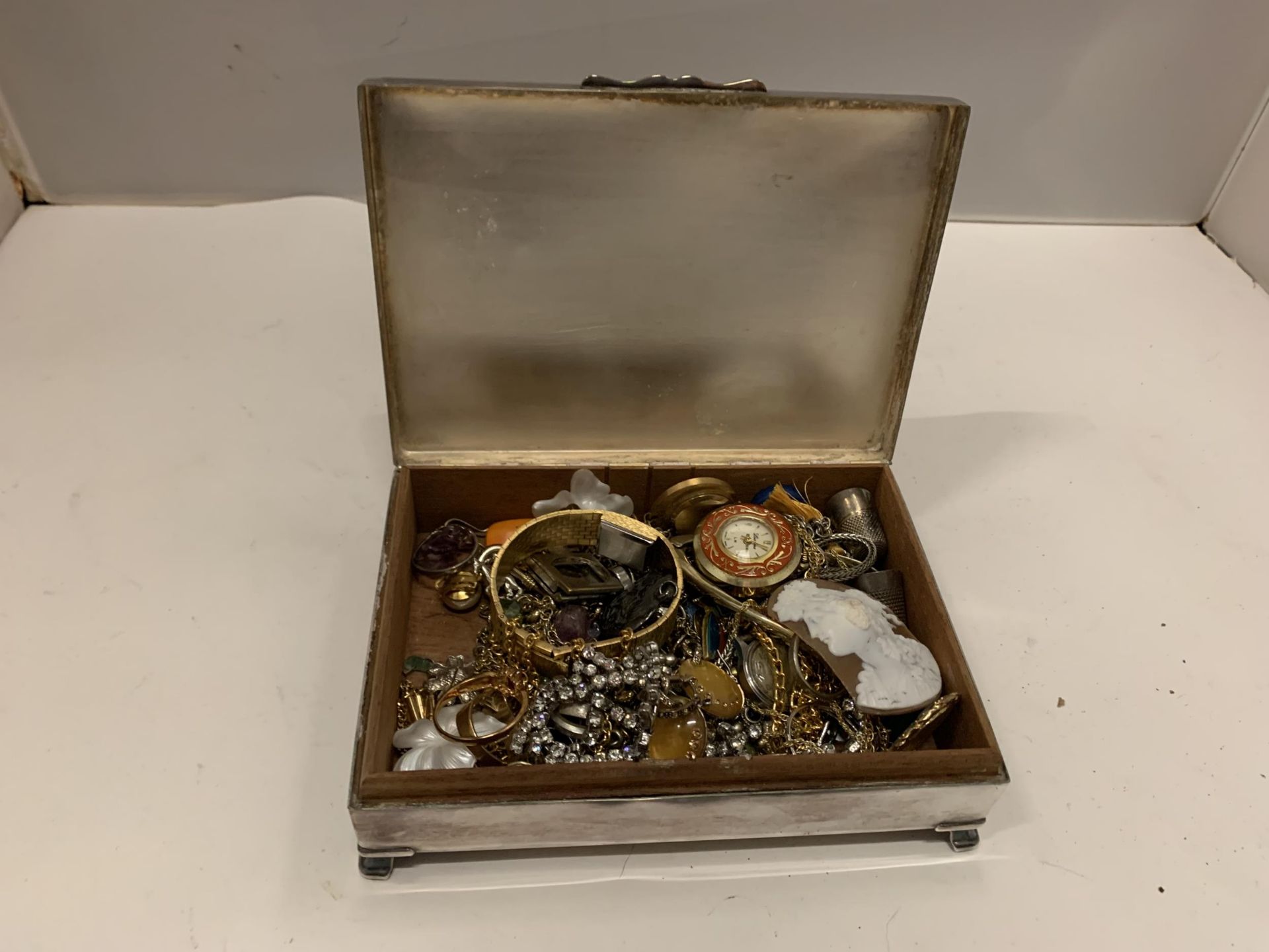 A SILVER PLATED BOX CONTAINING COSTUME JEWELLERY