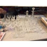 A LARGE SELECTION OF CUT GLASS DRINKING GLASSES AND DECANTERS TO INCLUDE WINE, CHAMPAGNE AND PORT