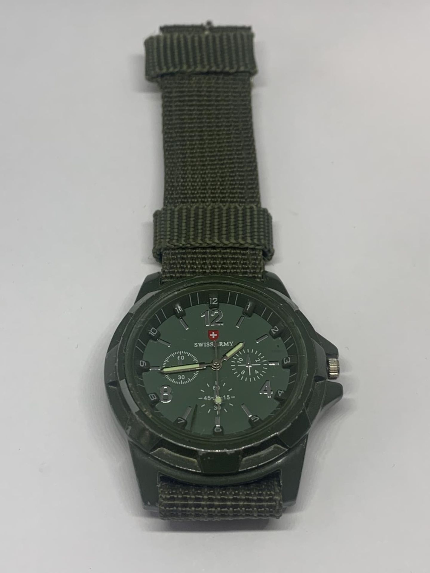 A SWISS ARMY WRISTWATCH WITH GREEN CANVAS STRAP SEEN WORKING BUT NO WARRANTY