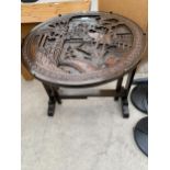 AN ORIENTAL HARDWOOD FOLDING TABLE/FIRE SCREEN, 234" DIAMETER, THE CARVED TOP DEPICTING JUNK AND