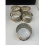 FIVE NAPKIN RINGS MARKED STERLING SILVER (FOUR MATCHING WITH A DESIGN AND ENGRAVED A AND ONE