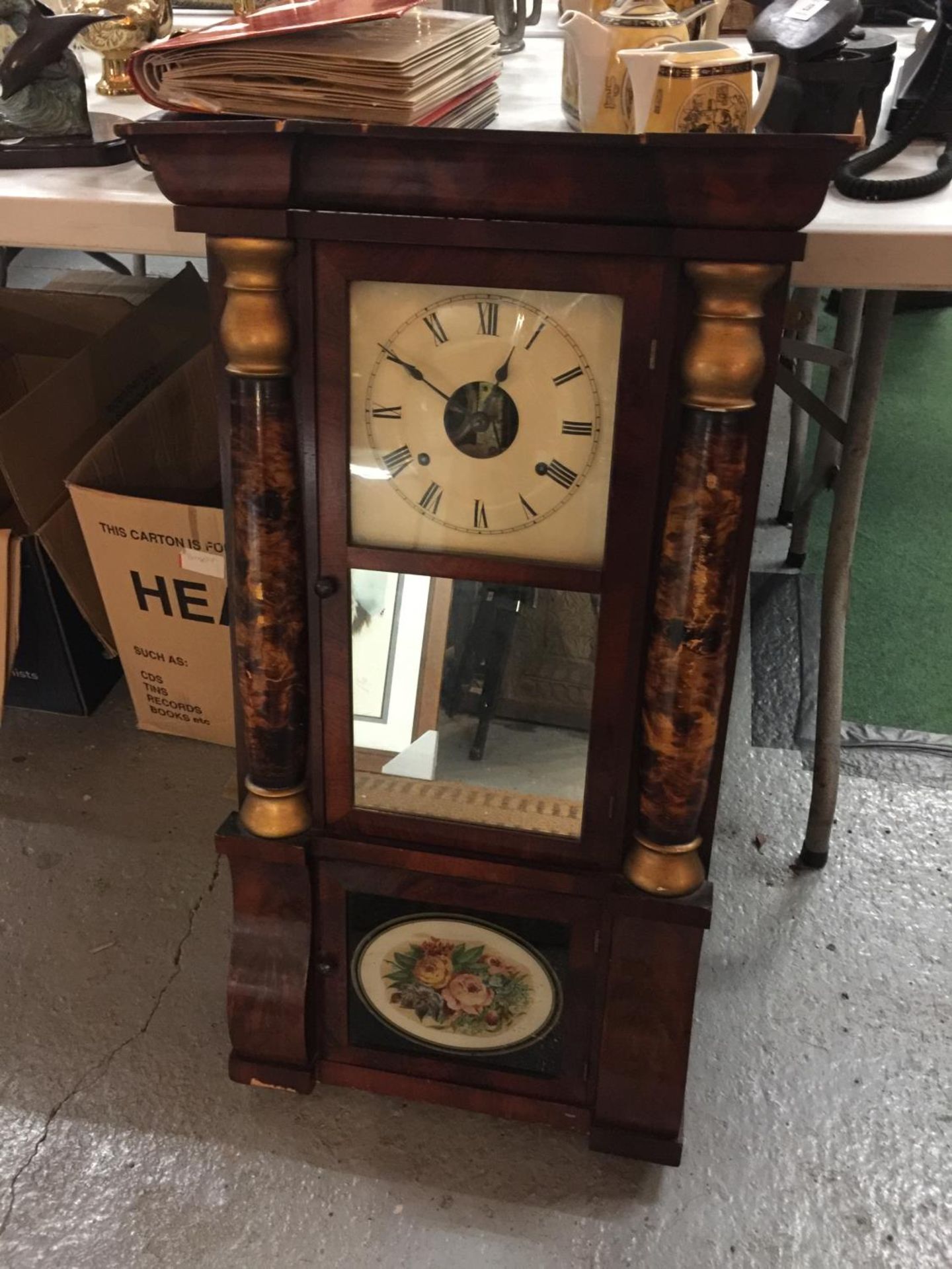 A VINTAGE STYLE WOODEN CASED WALL CLOCK WITH COLUMNS AND FLORAL DECORATED FRONT, COMPLETE WITH