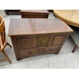 AN OAK GEORGIAN STYLE BLANKET CHEST WITH TWO DRAWERS TO THE BASE, TWO LINENFOLD PANELS AND CRESTED