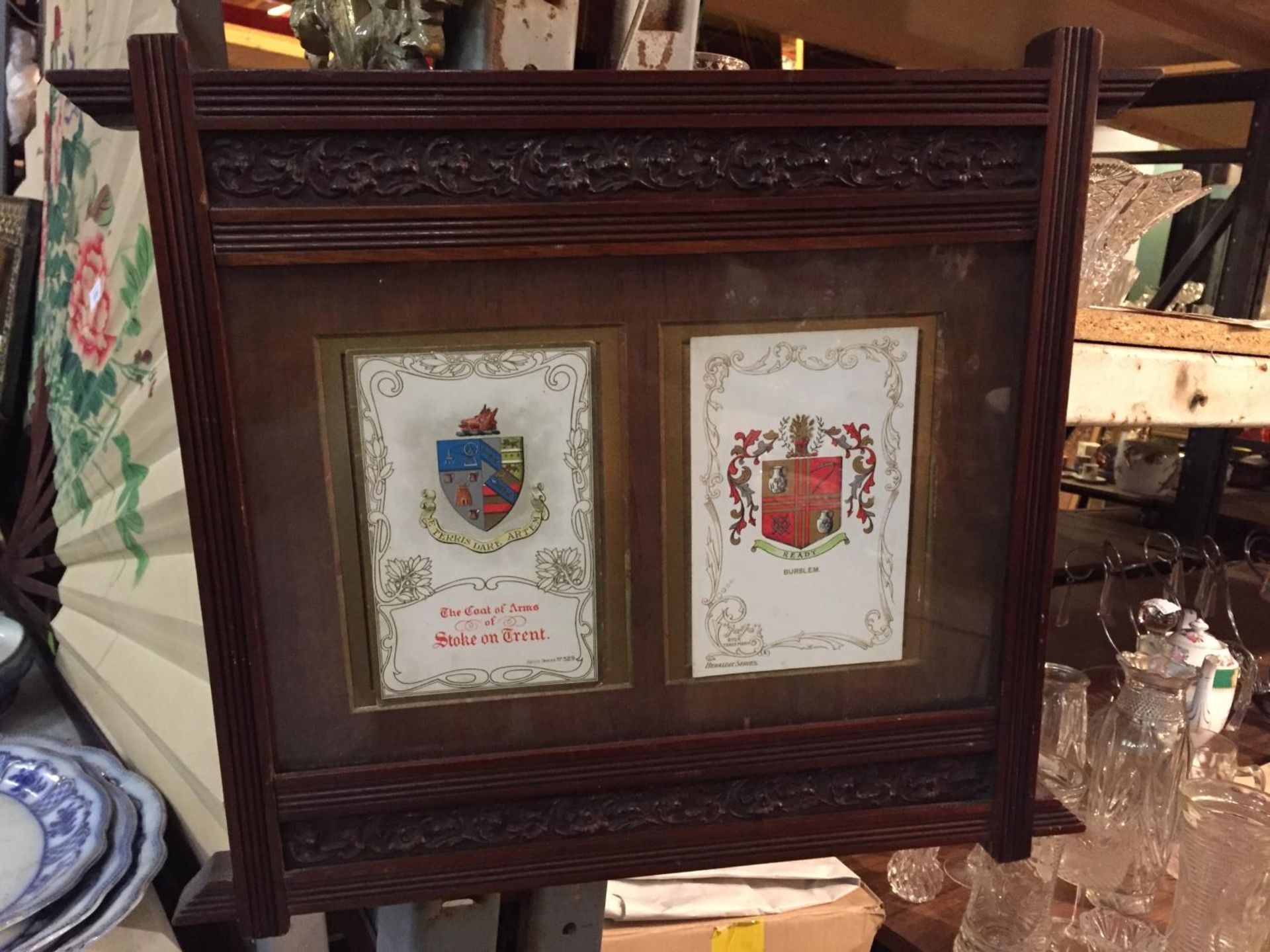 A WOODEN FRAMED COAT OF ARMS DEPICTING BURSLEM AND STOKE ON TRENT
