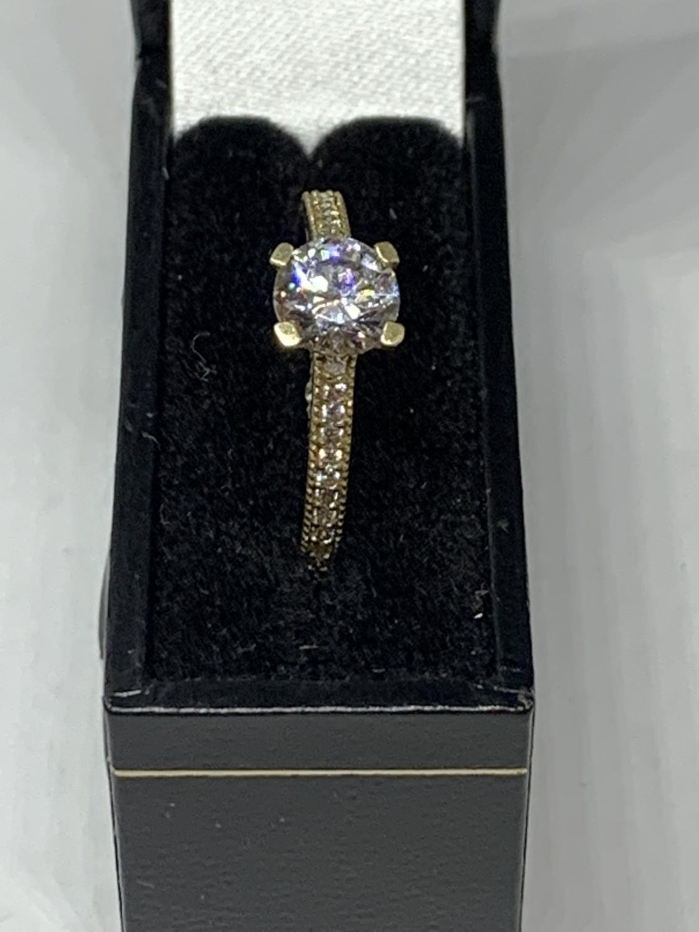 A 9 CARAT GOLD RING WITH A SINGLE CLEAR STONE AND CHIPS ON THE SHOULDERS SIZE O/P IN A - Image 4 of 4