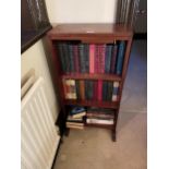 A MAHOGANY THREE TIER BOOKCASE CONTAINING VARIOUS BOOKS