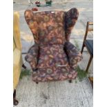 A PARKER KNOLL STYLE WINGED FIRESIDE CHAIR ON CABRIOLE LEGS