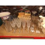 A NUMBER OF CRYSTAL DRINKING GLASSES A VASE AND TWO CANDLE STICKS