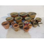 A collection of glazed and terracotta flower pots